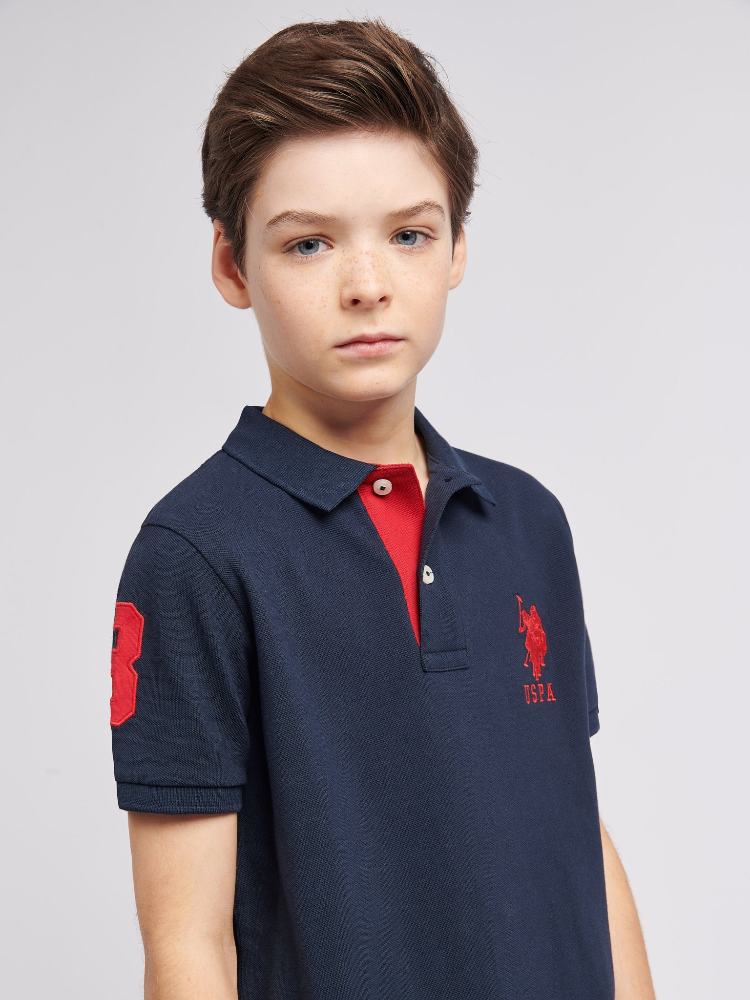 Boys Player 3 Polo Shirt in Dark Sapphire Navy / Haute Red DHM - Image 2